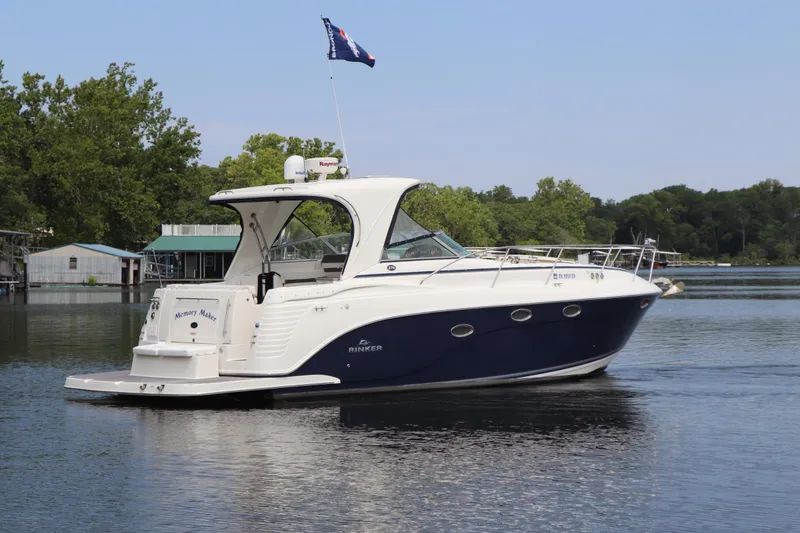 Slide: The Image of 2008 Rinker 370 boat cruising on a calm lake with trees in the background. - 6