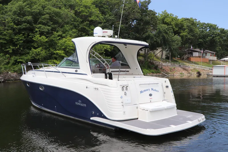 Slide: The Image of 2008 Rinker 370 boat on calm water near a wooded shoreline. - 8