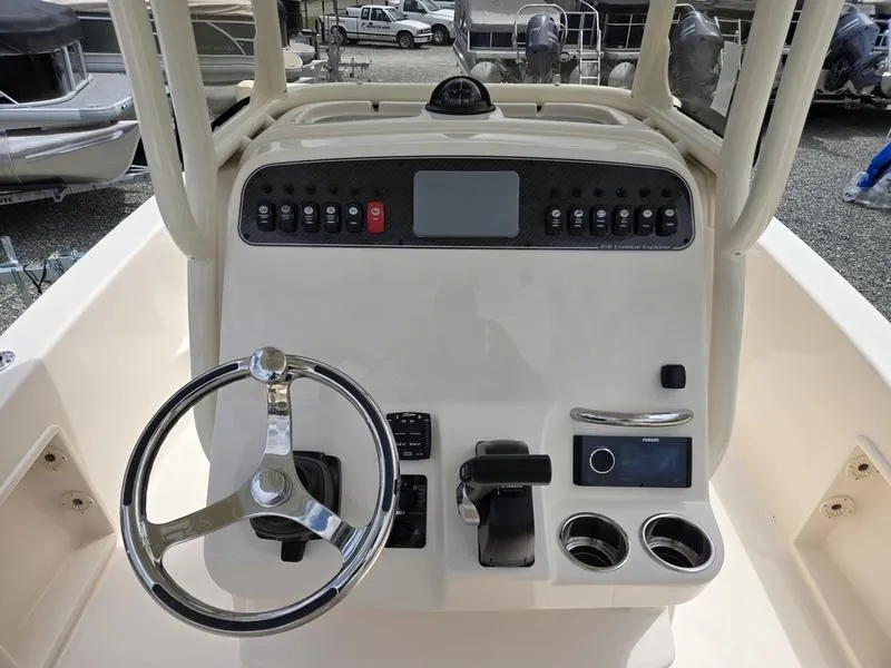 Slide: The Image of Grady-White 231 CE 2025 boat console with steering wheel, controls, and display. - 16