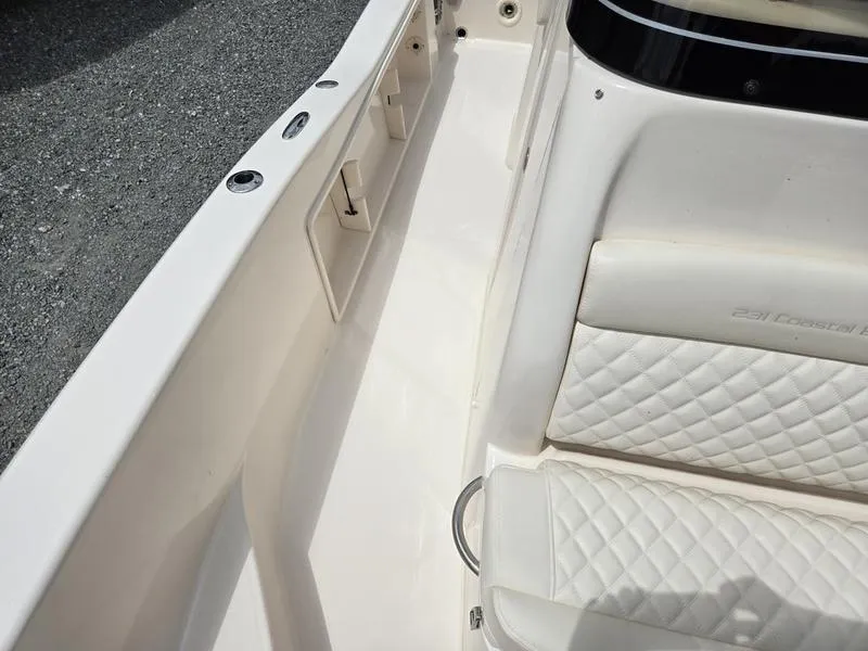 Slide: The Image of 2025 Grady-White 231 CE boat interior with white quilted seating and storage compartments. - 26
