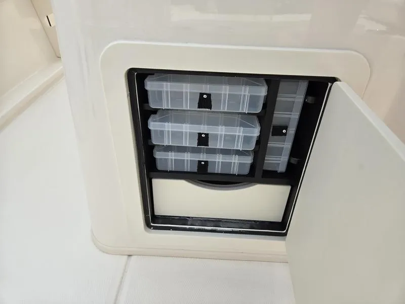 Slide: The Image of Storage compartment with tackle boxes on a 2025 Grady-White 231 CE boat. - 6