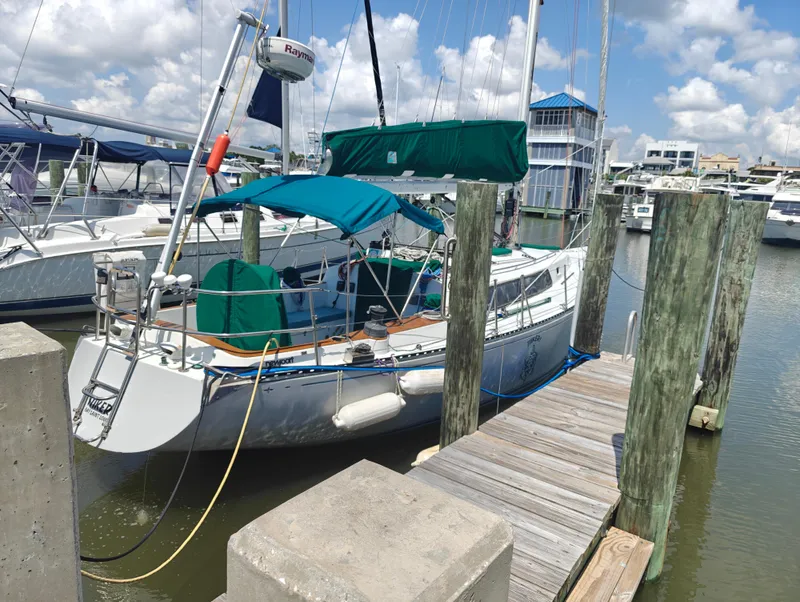 Slide: The Image of 1987 Newport MKII sailboat docked at marina under blue sky. - 1