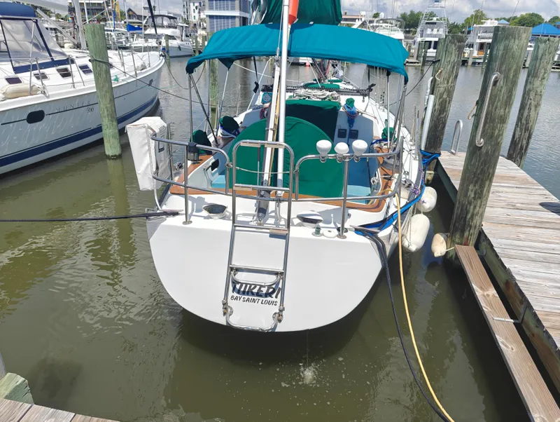 Slide: The Image of Newport MKII 1987 sailboat docked at marina with teal canopy and fenders. - 2