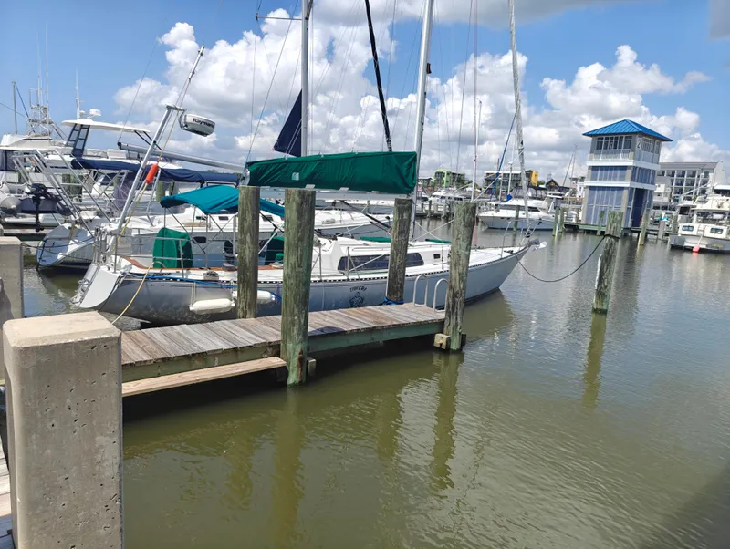 Slide: The Image of 1987 Newport MKII sailboat docked at a marina under a blue sky. - 3