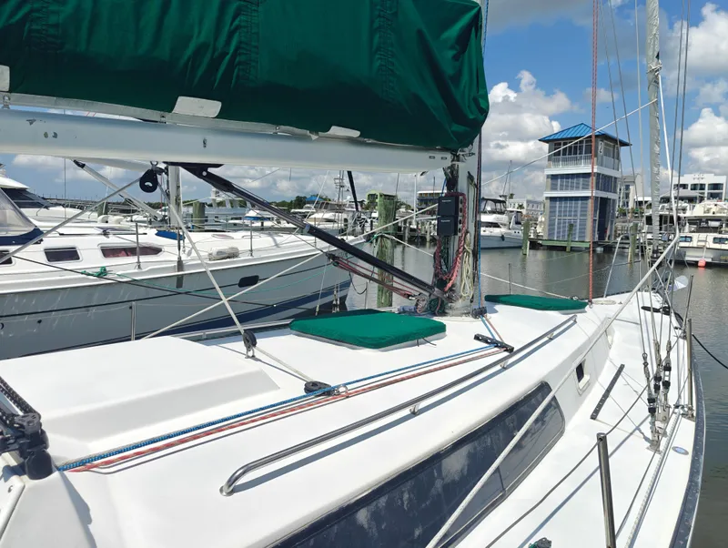Slide: The Image of 1987 Newport MKII sailboat docked at marina, featuring green sail cover and clear sky. - 5
