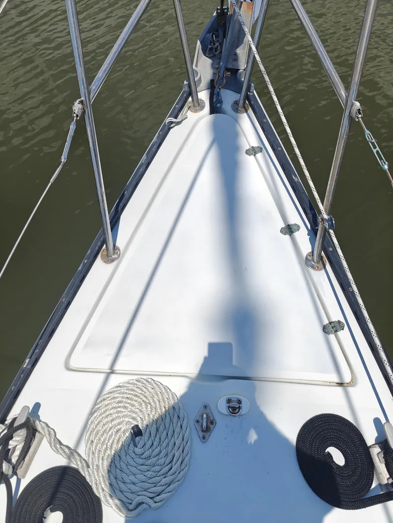 Slide: The Image of Bow of 1987 Newport MKII sailboat with coiled ropes and metal railings. - 7
