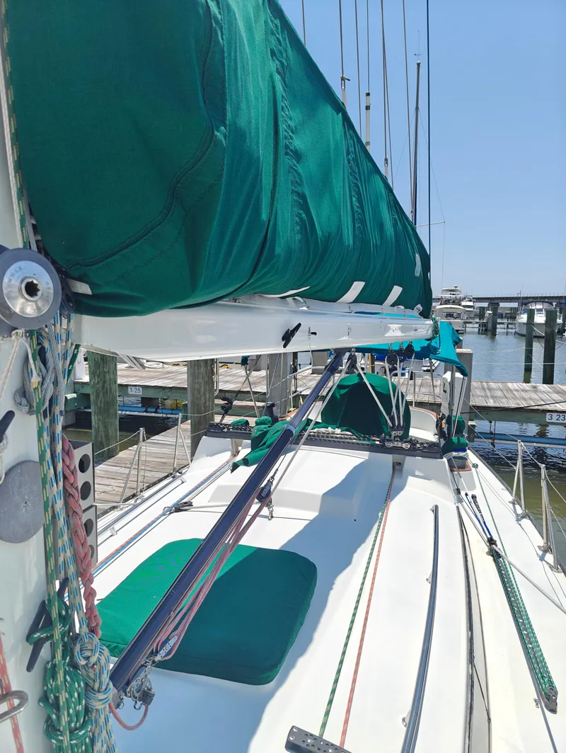 Slide: The Image of 1987 Newport MKII sailboat with green sail cover docked at marina. - 9