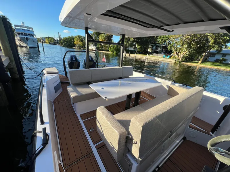 Slide: The Image of 2023 Axopar 37 Sun-Top boat with spacious seating and table on a sunny day. - 17