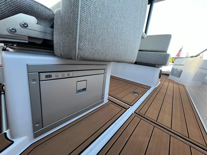 Slide: The Image of 2023 Axopar 37 Sun-Top boat interior with cushioned seating and teak flooring. - 33