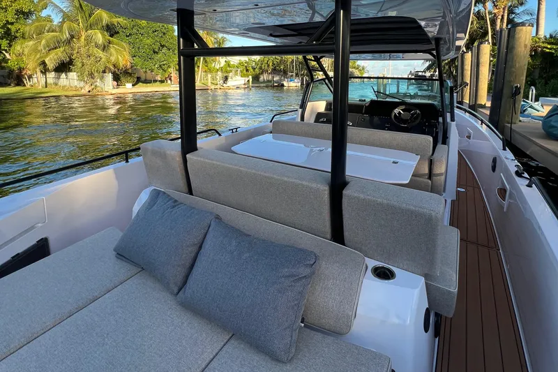 Slide: The Image of 2023 Axopar 37 Sun-Top boat interior with comfortable seating and scenic water view. - 45