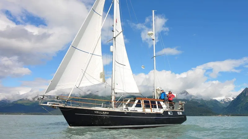 Slide: The Image of 1985 Nauticat 38 sailboat on calm waters with mountains in the background. - 0