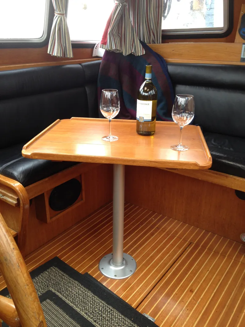 Slide: The Image of Interior of 1985 Nauticat 38 with wine bottle and glasses on wooden table. - 30