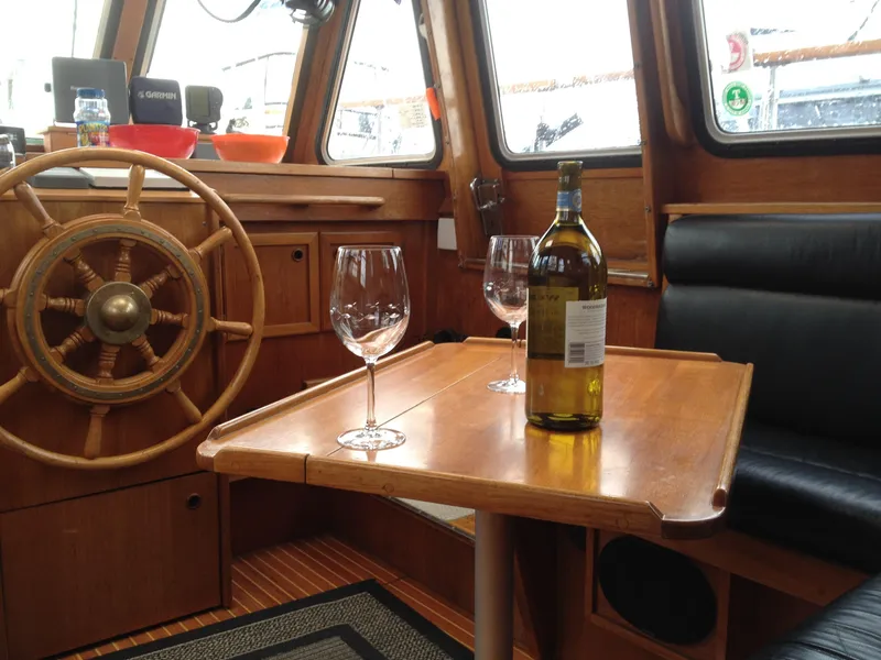 Slide: The Image of Interior of 1985 Nauticat 38 sailboat with wine bottle and glasses on table. - 31