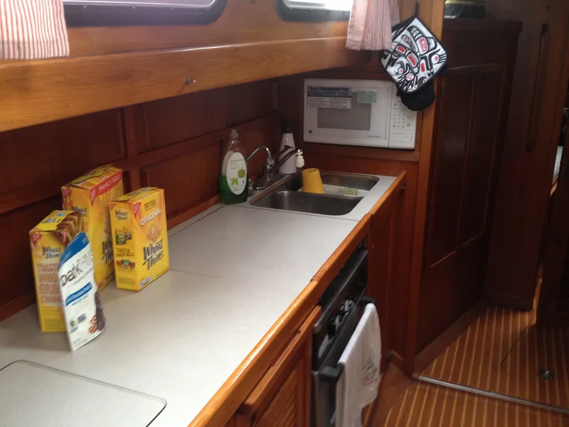Slide: The Image of Galley kitchen in a 1985 Nauticat 38 sailboat with cereal boxes and microwave. - 33