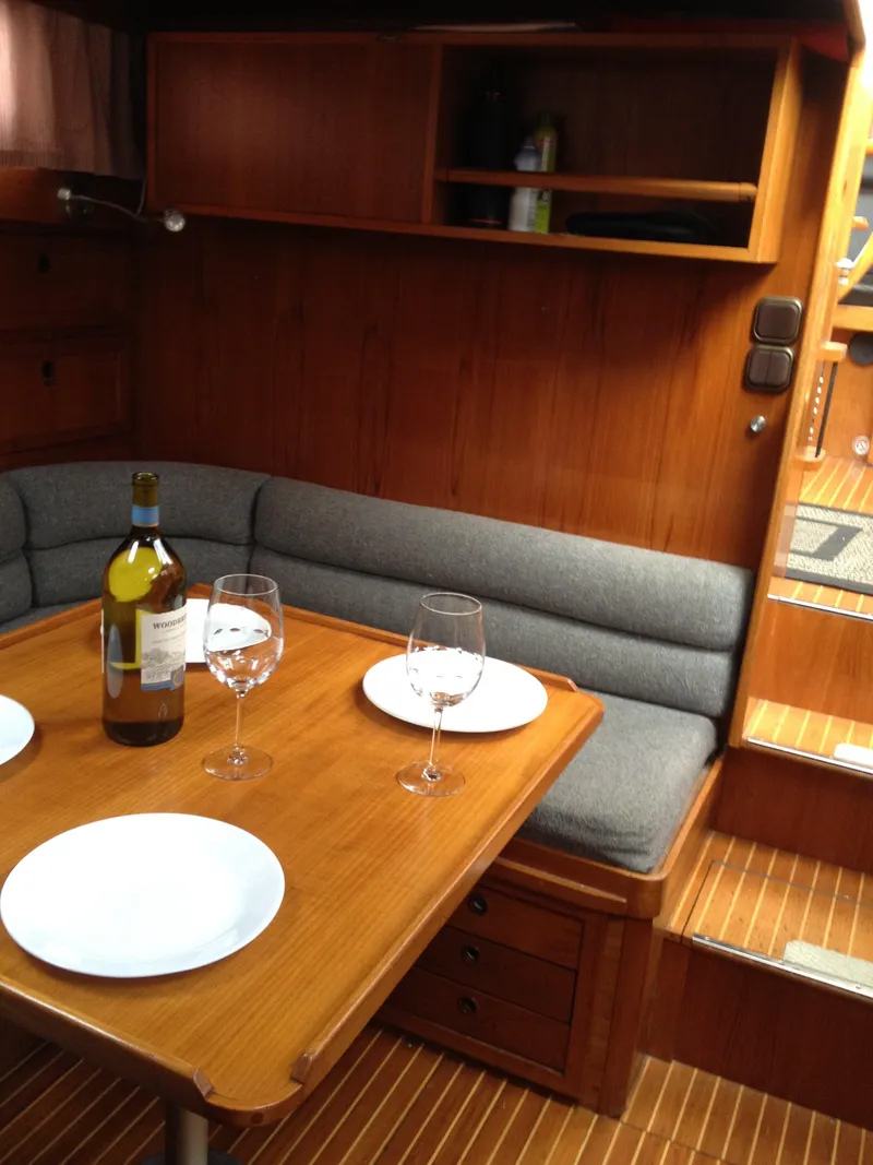 Slide: The Image of Interior of 1985 Nauticat 38 sailboat with dining table, wine, and seating. - 35