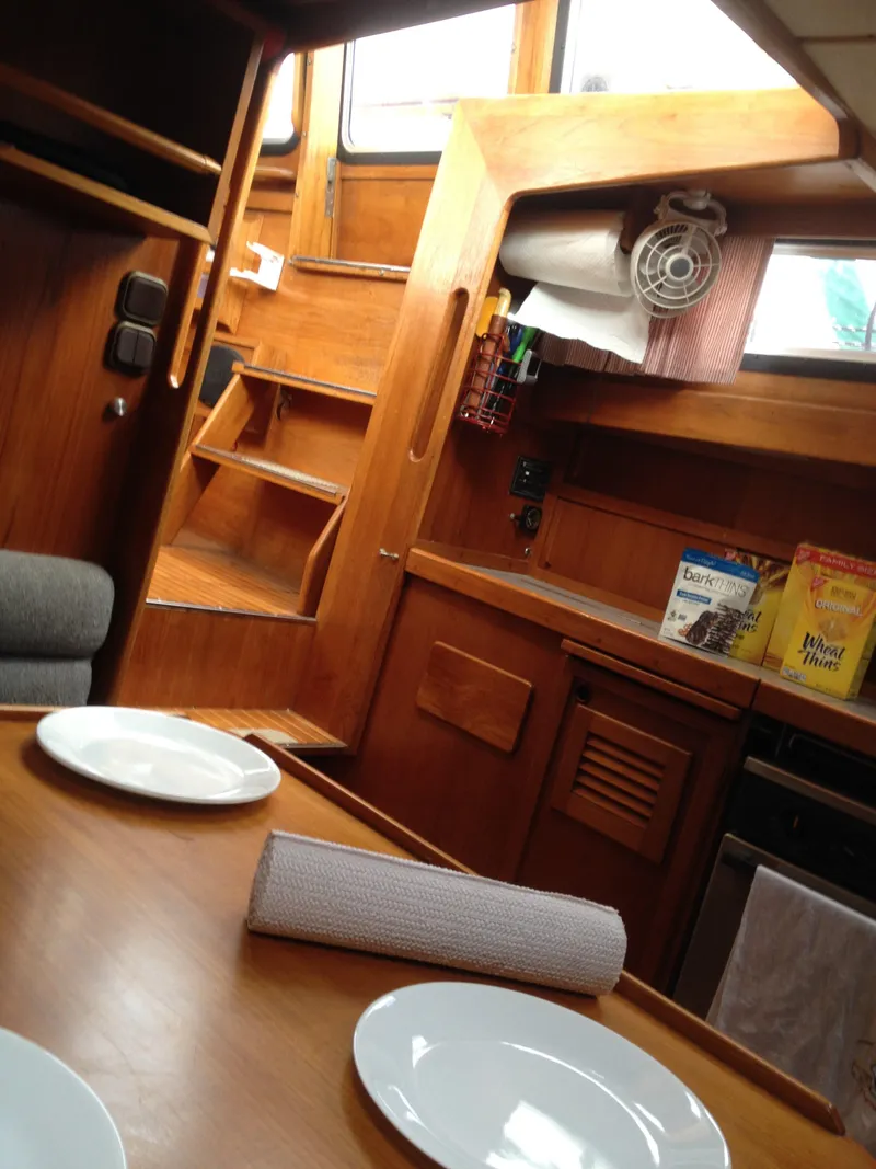 Slide: The Image of Interior of a 1985 Nauticat 38 sailboat with wooden cabinetry and dining area. - 42