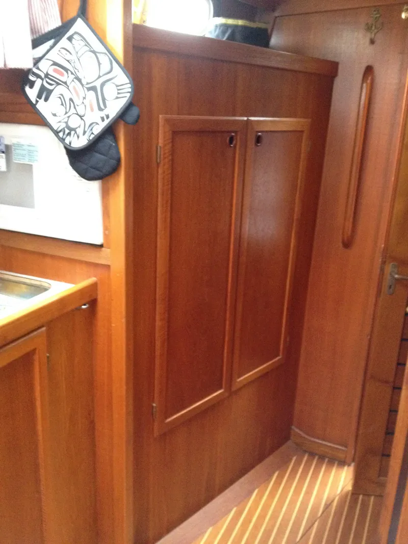 Slide: The Image of 1985 Nauticat 38 interior with wooden cabinetry and kitchen area. - 44