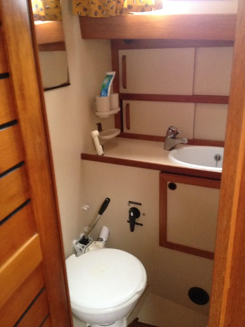 Slide: The Image of Compact bathroom in a 1985 Nauticat 38 sailboat with sink and toilet. - 46