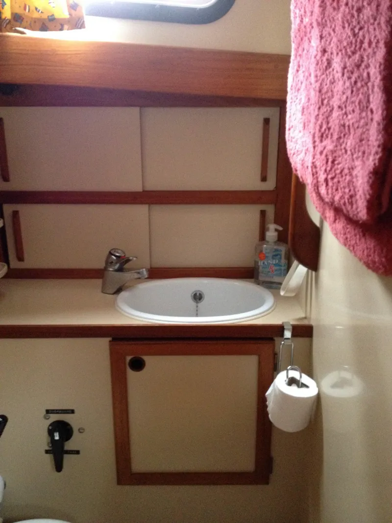 Slide: The Image of 1985 Nauticat 38 boat bathroom with sink, storage cabinets, and towel. - 47