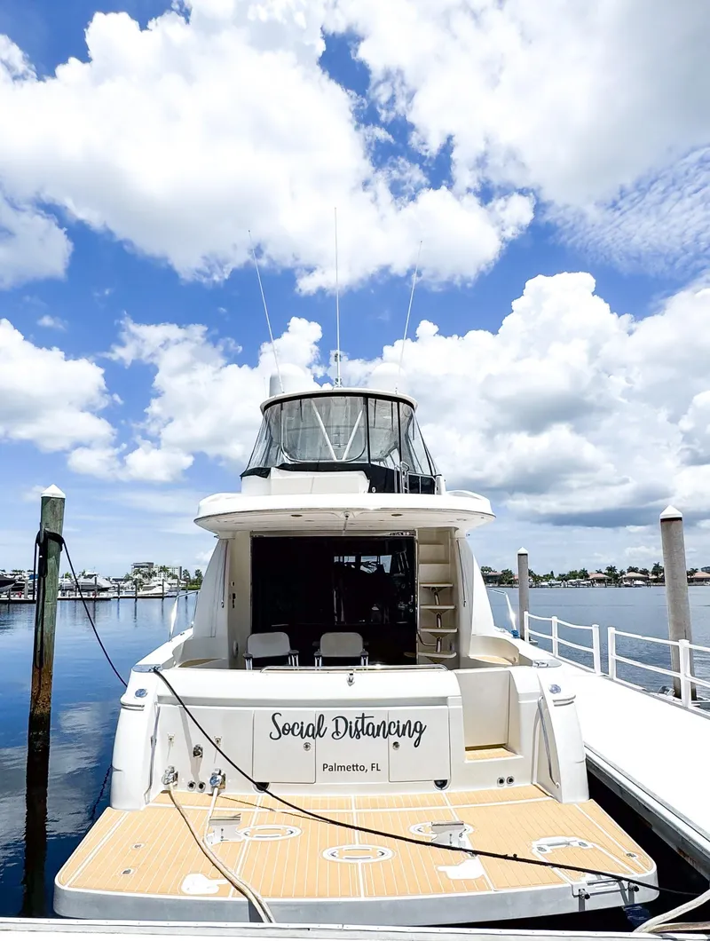 Slide: The Image of 2006 Carver 560 Voyager yacht docked under a bright blue sky. - 49