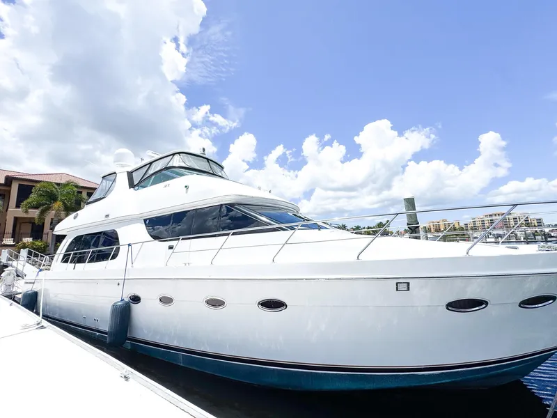 Slide: The Image of 2006 Carver 56 Voyager yacht docked under a bright blue sky. - 2