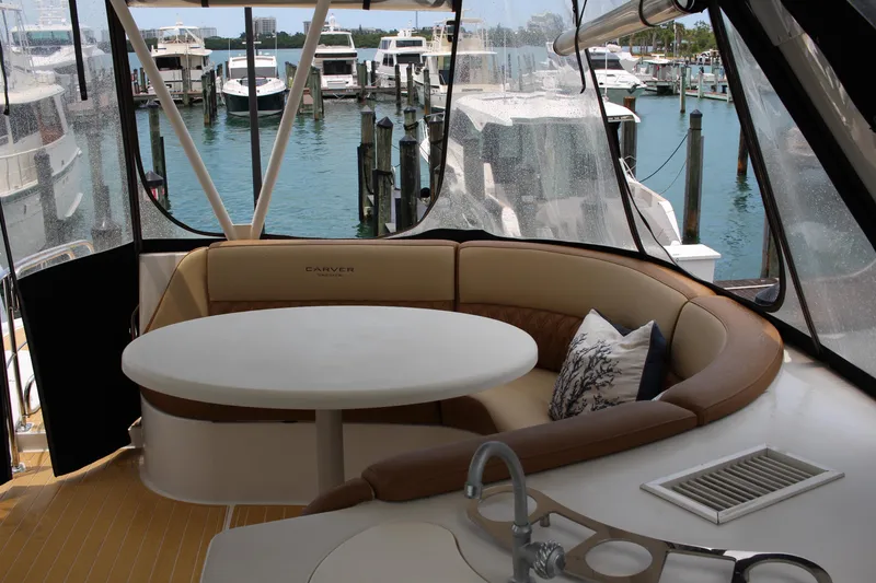 Slide: The Image of 2006 Carver 560 Voyager yacht interior with round table and seating area at marina. - 23