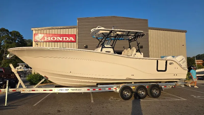 The Image of 2022 Sea Fox 328 Commander boat on a trailer outside a Honda dealership. - 1