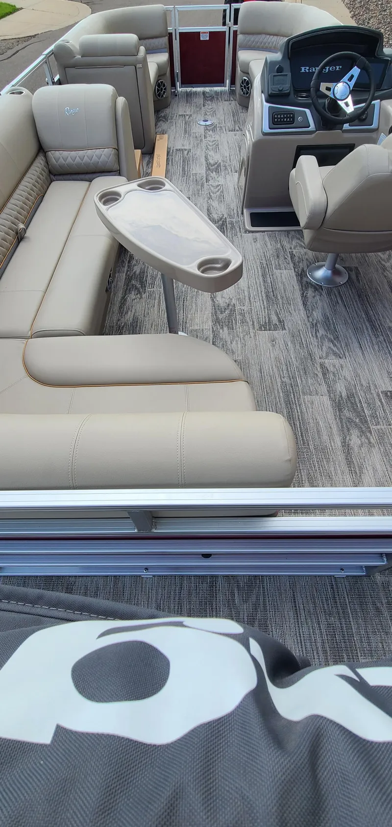 Slide: The Image of 2024 Ranger Reata 220C boat interior with beige seating and modern dashboard. - 2