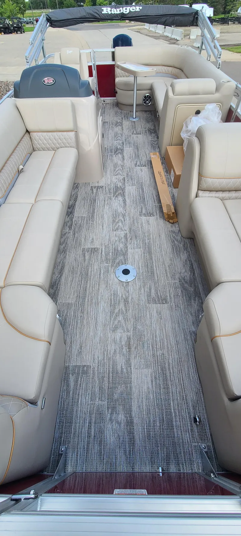 Slide: The Image of 2024 Ranger Reata 220C pontoon boat interior with beige seating and gray flooring. - 4