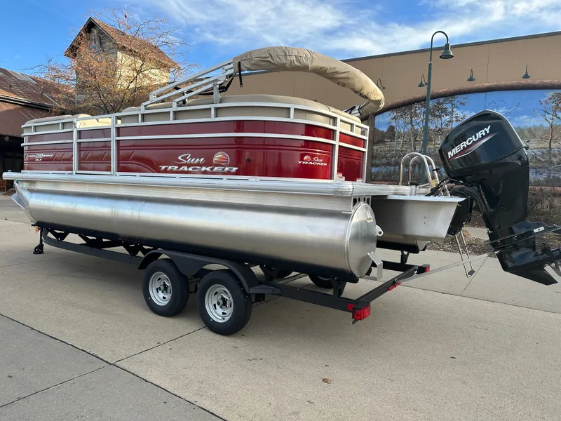 Slide: The Image of 2024 Sun Tracker Party Barge 20 DLX pontoon boat on trailer with Mercury outboard motor. - 2