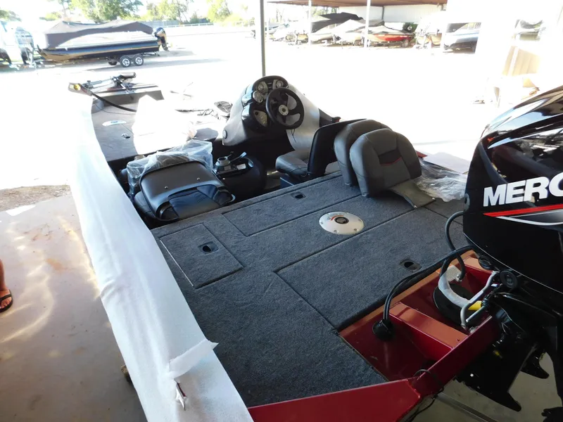 Slide: The Image of 2024 Tracker Pro 170 boat interior with Mercury engine, featuring spacious seating and steering console. - 26