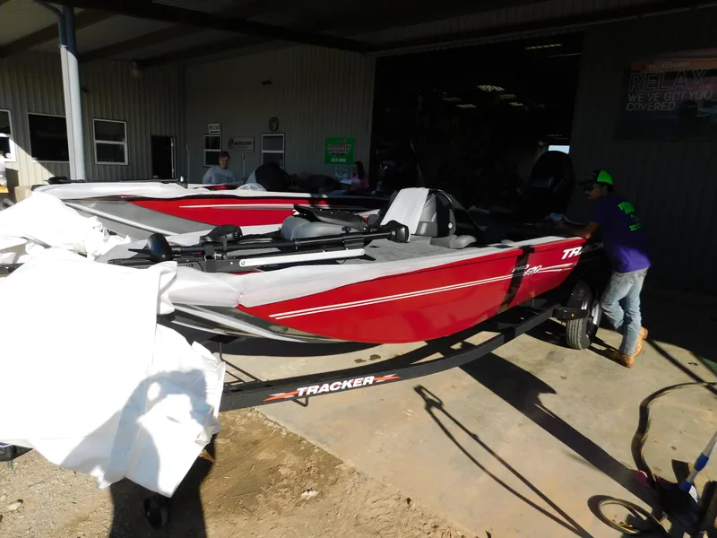 Slide: The Image of 2024 Tracker Pro 170 boat in red, parked in a garage, partially covered. - 29