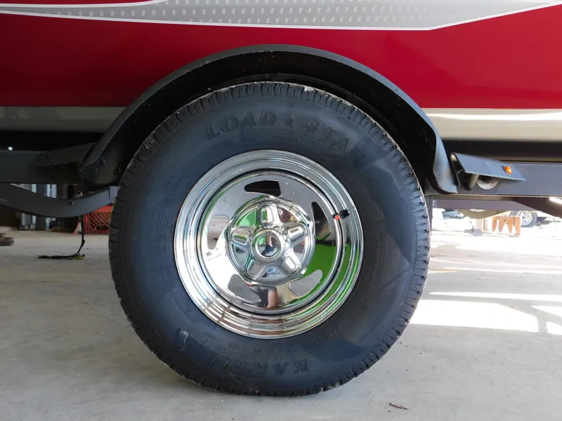 Slide: The Image of 2024 Tracker Pro 170 trailer wheel with chrome hubcap and black tire. - 38