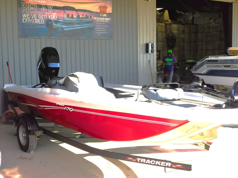 Slide: The Image of 2024 Tracker Pro 170 boat in a garage, red exterior, on a trailer. - 4