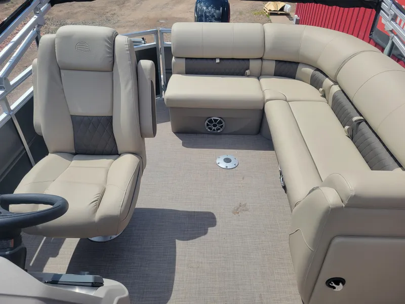 Slide: The Image of 2024 Sun Tracker Party Barge 20 DLX interior with beige seating and steering console. - 4