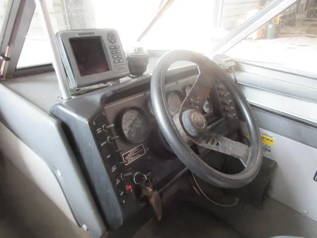 Slide: The Image of 1990 Lund 1850 Tyee Gran Sport boat dashboard with steering wheel and electronics. - 10