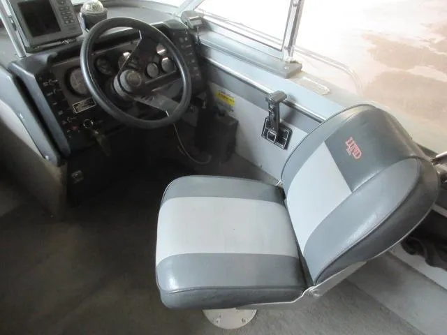 Slide: The Image of 1990 Lund 1850 Tyee Gran Sport boat cockpit with steering wheel and seat. - 16