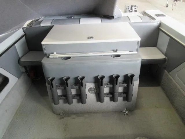 Slide: The Image of 1990 Lund 1850 Tyee Gran Sport boat interior with storage compartments and rod holders. - 17