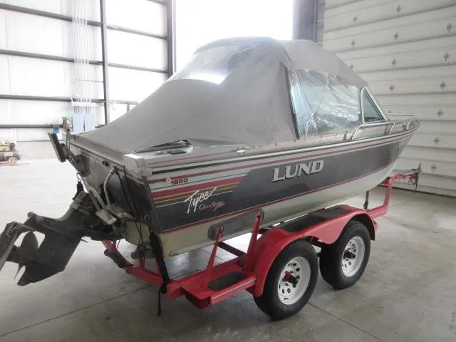 Slide: The Image of 1990 Lund 1850 Tyee Gran Sport boat on a red trailer in a warehouse. - 5