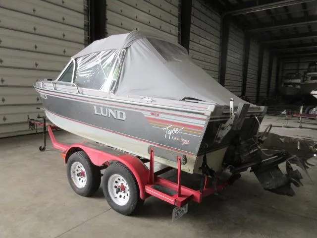 Slide: The Image of 1990 Lund 1850 Tyee Gran Sport boat on a red trailer in storage. - 9