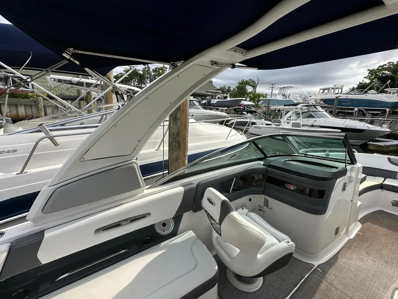 Slide: The Image of 2018 Chaparral 267 SSX boat interior with seating and helm, docked at marina. - 17