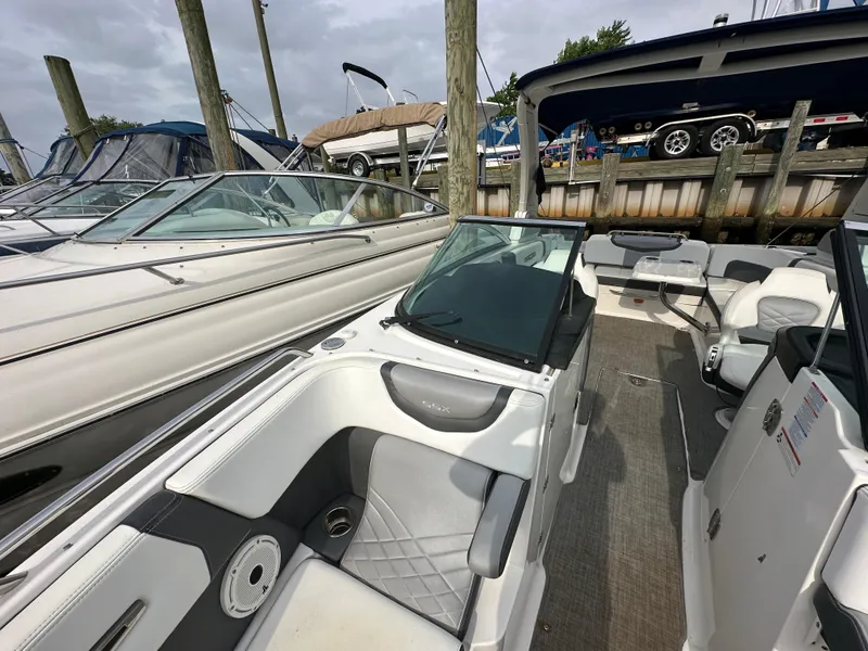 Slide: The Image of 2018 Chaparral 267 SSX boat docked at a marina with other boats. - 19