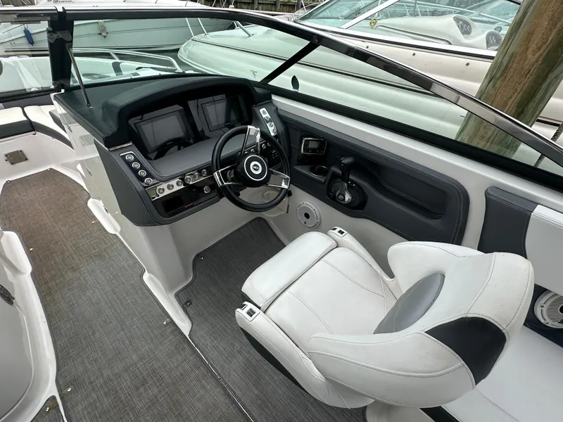 Slide: The Image of 2018 Chaparral 267 SSX boat cockpit with steering wheel and control panel. - 2