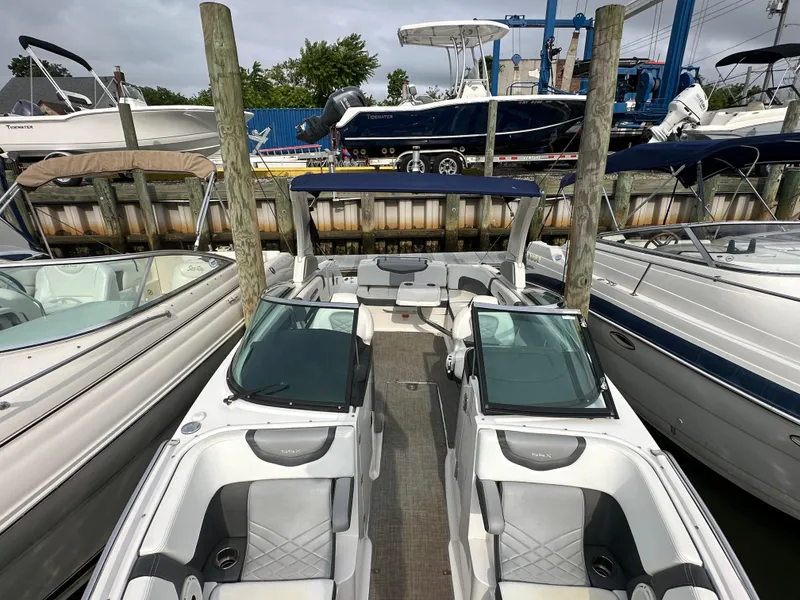 Slide: The Image of 2018 Chaparral 267 SSX boat docked among other boats at a marina. - 20
