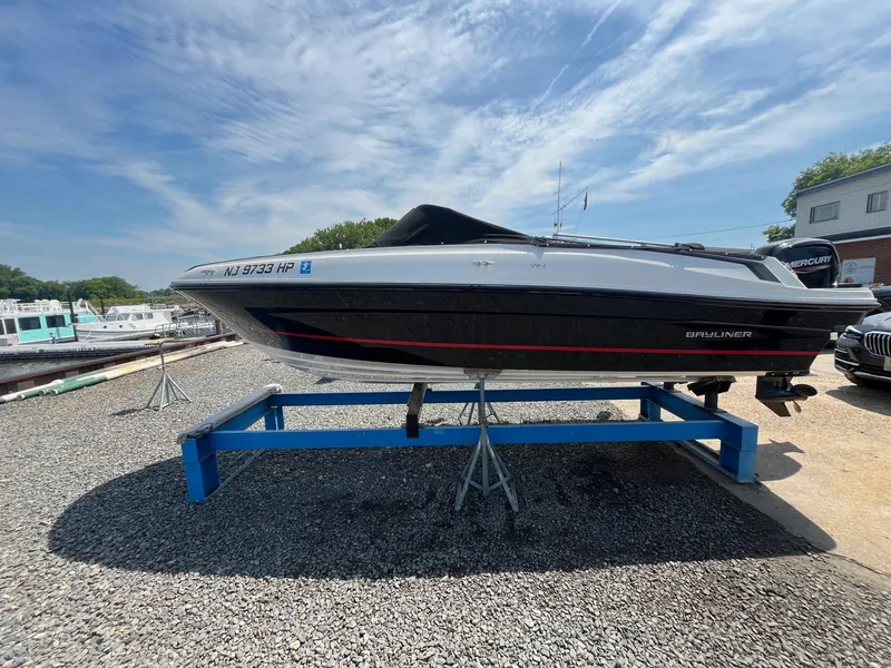 Slide: The Image of 2022 Bayliner VR4 Bowrider OB on display stand under clear sky. - 2