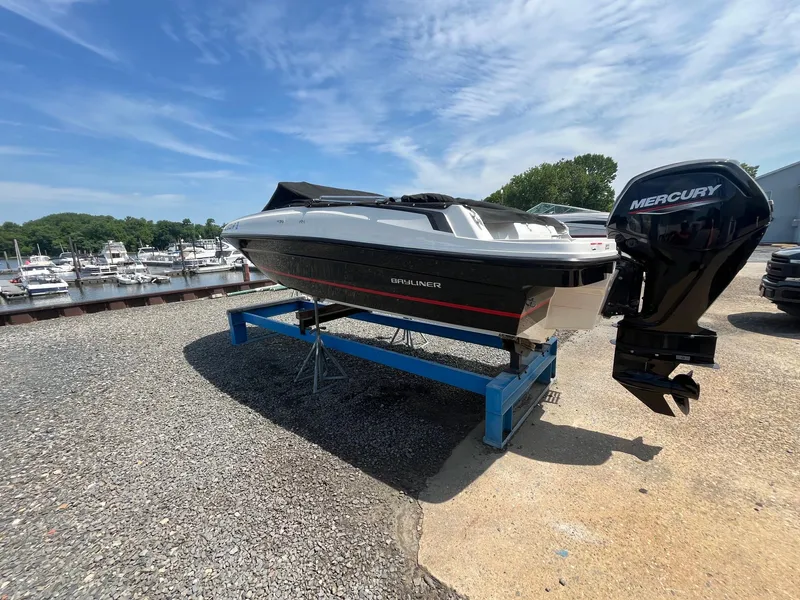 Slide: The Image of 2022 Bayliner VR4 Bowrider OB on stand, with Mercury outboard, near marina. - 3