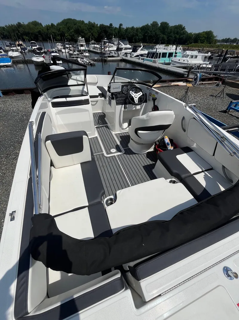 Slide: The Image of 2022 Bayliner VR4 Bowrider OB with sleek interior, docked at a marina. - 4