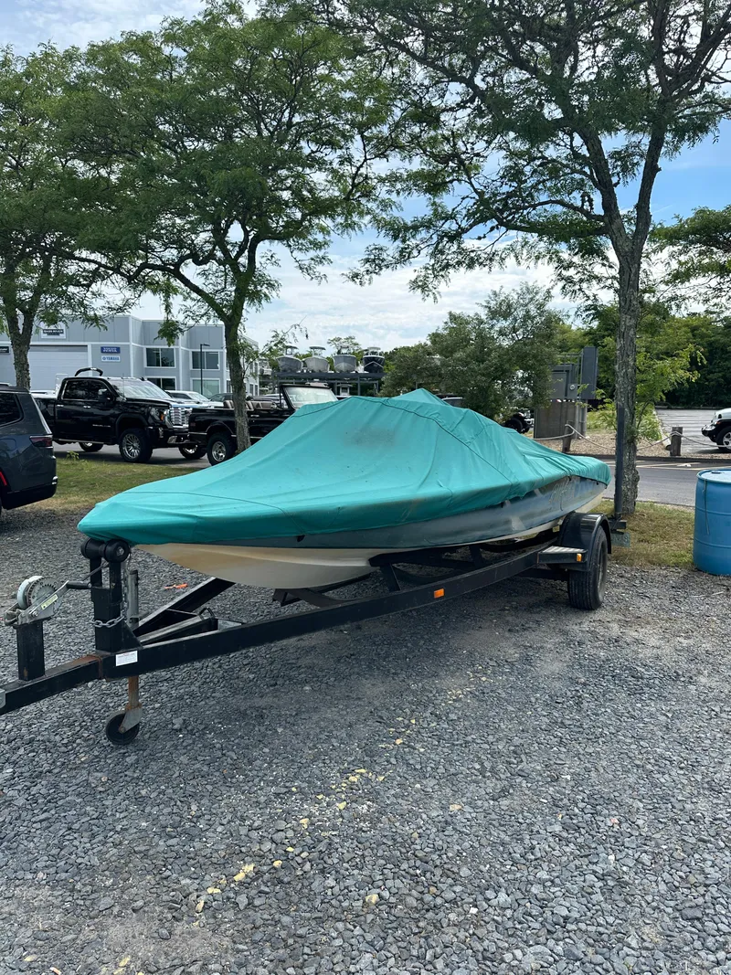 Slide: The Image of 1998 Gekko GTS-20 boat on a trailer, covered with a green tarp. - 10