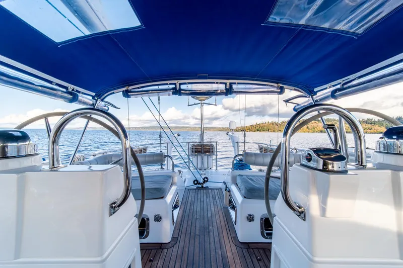Slide: The Image of Luxury Hylas 70 yacht interior with blue canopy, dual steering wheels, and scenic ocean view. - 16