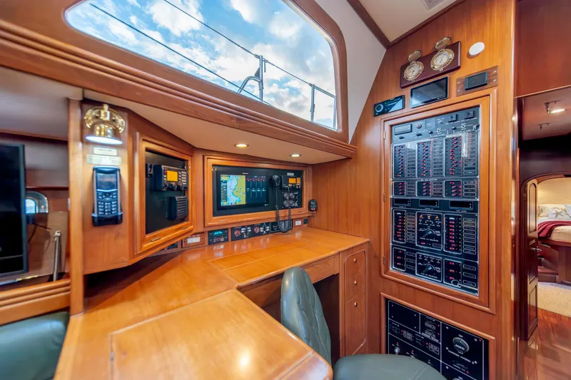 Slide: The Image of Navigation station inside 2010 Hylas 70 yacht with control panels and seating. - 28